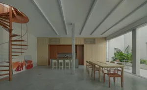 A minimalist dining room with wooden furniture and a large window.