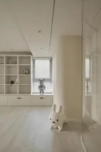 A minimalist playroom with neutral-colored walls, wooden floors, and a white rabbit figure.