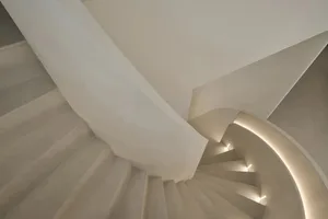 Modern concrete staircase with illuminated railings.