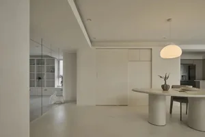 Minimalist dining room with modern touches, featuring a marble dining table and white walls.