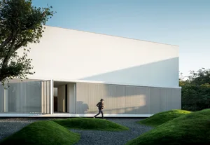 A modern minimalist residential building with a white painted concrete exterior.