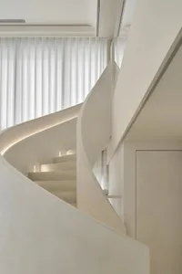 Modern minimalist staircase with concrete walls and hidden lighting in a sleek, contemporary interior design setting.