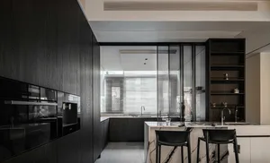 Modern kitchen with dark wood cabinets, marble countertops, and black stools.