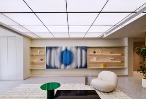 A modern living room featuring a wall-mounted abstract mural with geometric patterns, complemented by a curved white armchair