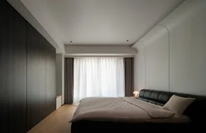 Modern minimalist bedroom featuring a black bed with white curtains.
