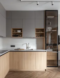 Modern minimalist kitchen with white marble countertops and wooden cabinets.
