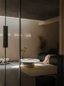 Modern minimalist living room featuring metal and glass elements.