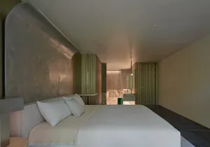 A modern bedroom with neutral-toned materials and a minimalist design.