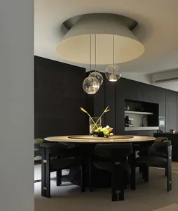 A modern dining room with a marble table and pendant lights above.