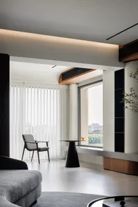 Modern interior design of a living room featuring a large window with vertical blinds.