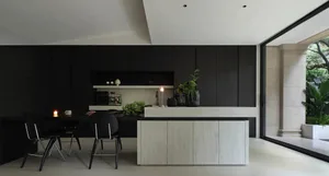 Contemporary kitchen with black cabinets and white countertops.