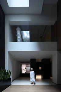A modern living room with a glass wall featuring a spiral staircase.