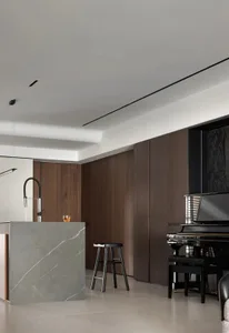 A modern living room featuring wooden panels and marble accents.