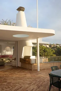 Modern minimalist balcony area with a glass wall and concrete floor.