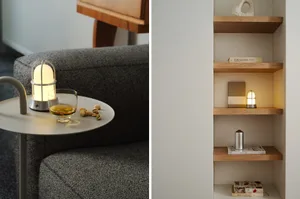 A modern shelf displaying wooden objects and books with a small, illuminated lamp.