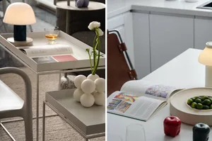 A modern kitchen with minimalist design, featuring white countertops and a white table with a vase of flowers and a book.