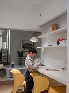 A modern indoor environment with white walls and yellow plastic chairs designed for children.