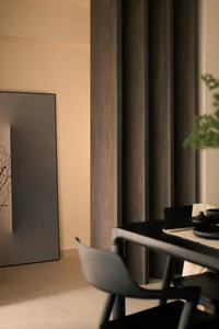 Modern minimalist dining room with black wooden panels and chairs.