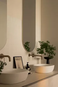 Modern bathroom featuring a white concrete sink and white textured tiles on the wall.