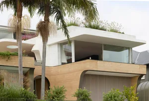 A modern house exterior featuring concrete materials and lush greenery.