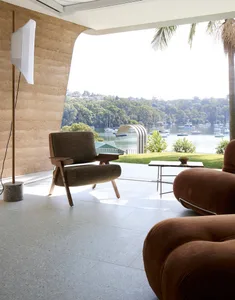 Modern living room featuring ergonomic leather furniture and a large waterfront view.