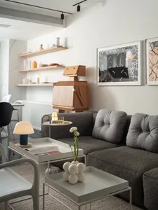 A modern living room with a textured gray sofa, metal coffee table, and wooden coffee table.