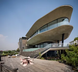 A modern residential house with a concrete exterior and black pillars.