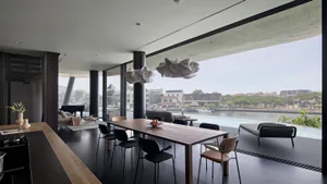 A modern residential interior featuring concrete, glass, and wood materials.