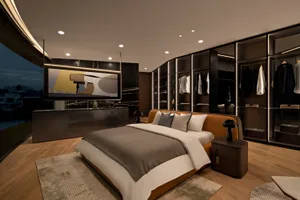 Modern bedroom featuring a brown leather bed with a glass headboard and wood flooring.