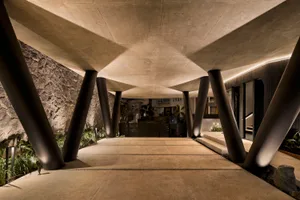 A modern entrance featuring a concrete structure with large pillars.