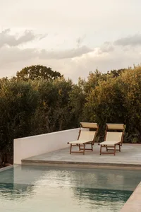 A modern outdoor patio with concrete elements and sun loungers.