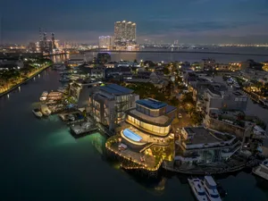 Aerial view of luxury waterfront residences featuring modern architectural elements such as glass, concrete, and steel.