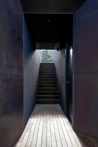A minimalist interior with a metal staircase.