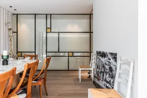Modern dining room featuring a marble table and chairs with patterned cushions.