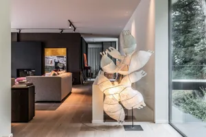 A modern industrial living room with a comfortable fabric sofa and abstract mural wall art.