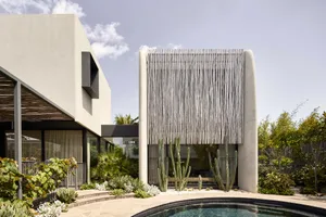 A modern concrete residence featuring cactus plants in its garden