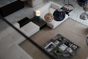 Modern living room featuring a white sofa and marble flooring.