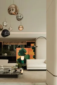 A modern living room featuring metallic pendant lights, a white sofa, and a colorful abstract artwork.