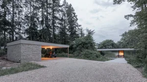 A modern residential exterior with stone, glass, and metal elements.
