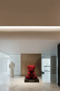 A modern retail interior featuring a vibrant red floral bear sculpture.
