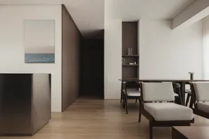 Modern minimalist living room with wooden furniture, fabric upholstery, and metal accents.
