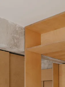 Modern interior featuring wooden shelving unit with exposed concrete corner