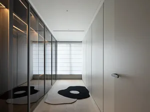 A minimalist white closet with glass doors and wooden floor.