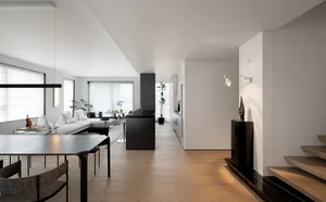 A modern minimalist apartment showcasing sleek design features and functional zones.