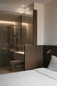 Modern minimalist bathroom featuring glass shower enclosure, wood paneling, and concrete flooring.