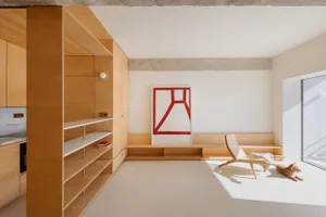 A minimalist living area with a wooden feature wall and a geometric art piece.