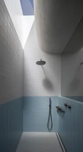 Modern bathroom with white and grey ceramic tiles and concrete roof