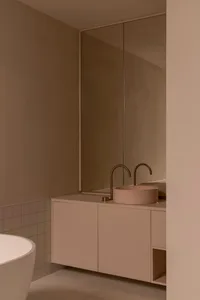 A minimalist bathroom with a concrete countertop and double sink.