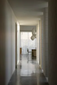 A modern corridor with concrete flooring and a minimalist design aesthetic.
