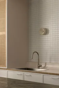 Minimalist, metal kitchen sink with stainless steel faucet and stone countertop.